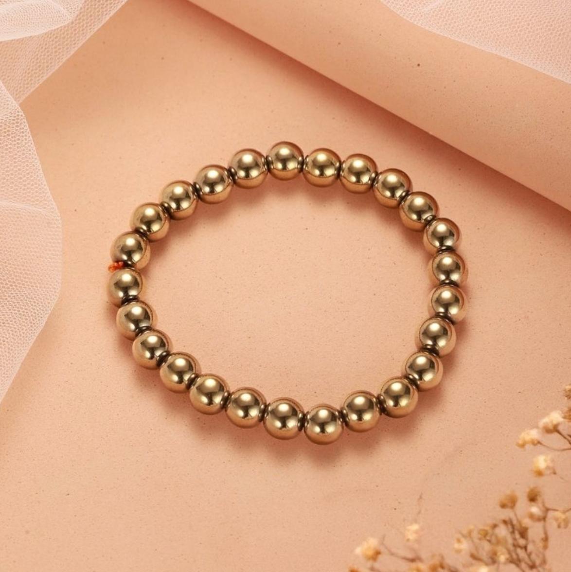 Golden hematite bracelet on a soft pink background