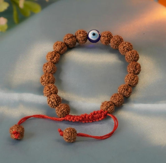 5 Mukhi Rudraksh bracelet with a red string and a blue evil eye bead on a light gray background.